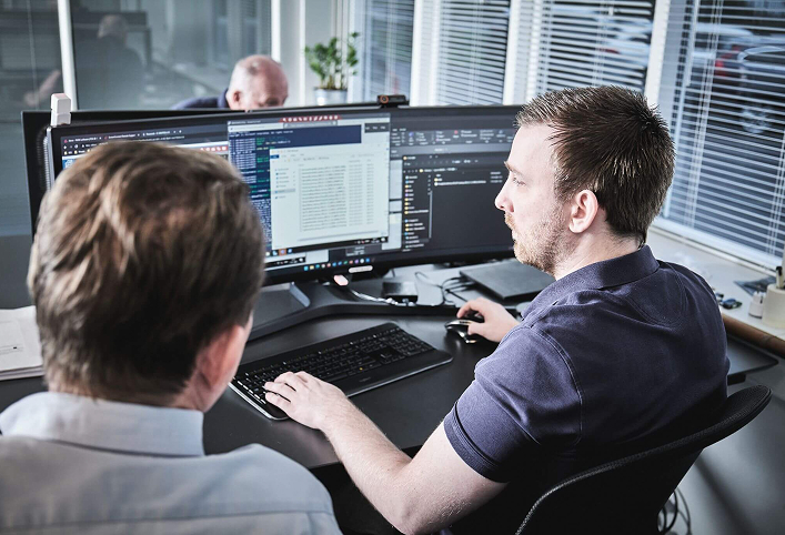 Personer samarbejder foran en computer