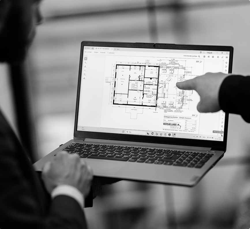 Mand holder laptop med plantegning åben